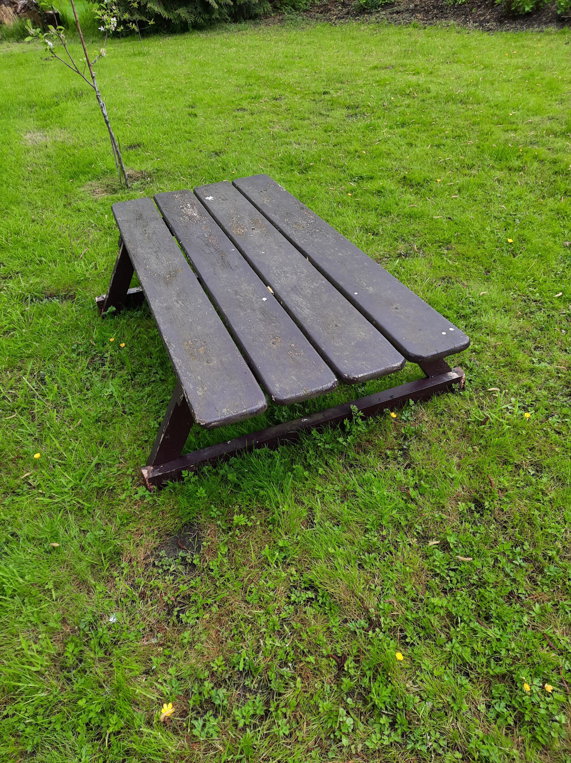Oude afgezaagde houten picknicktafel.