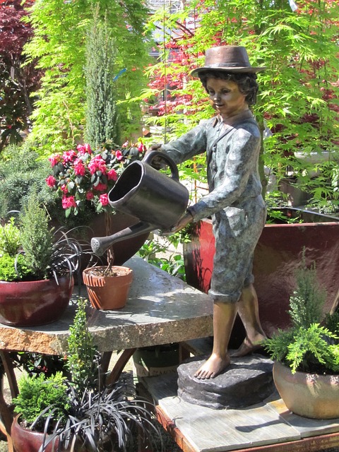 Een leuke tuin door een bronzen beeld en tuinbeelden.