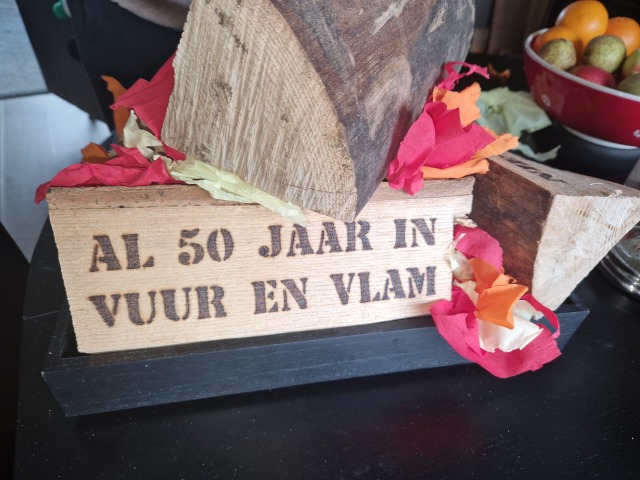 Gebrande tekst op haardblok Al 50 jaar in vuur en vlam.